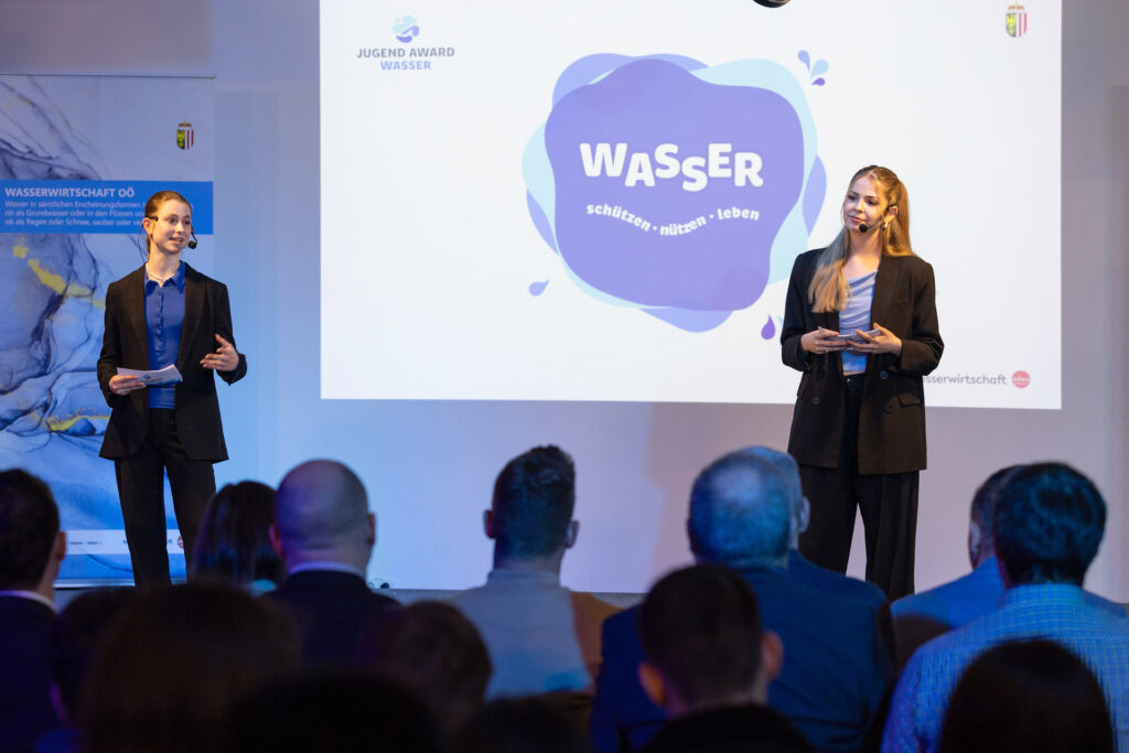 Zwei Moderatorinnen präsentieren beim Jugend Award Wasser vor Publikum in Oberösterreich.